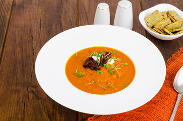 Delicious vegetable cream soup with tomatoes and microgreens.