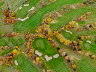 Aerial view of a golf course. Beautiful colorful trees and green course during autumn/winter season in the South of Belgium, Walloon Brabant.