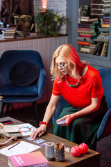Fototapeta premium Blonde-haired astrologist feeling busy while reading oracle cards