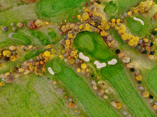 Aerial view of a golf course. Beautiful colorful trees and green course during autumn/winter season in the South of Belgium, Walloon Brabant.