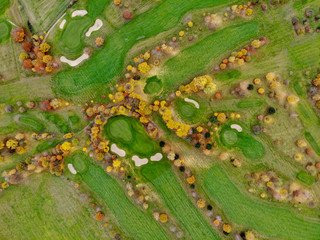 Aerial view of a golf course. Beautiful colorful trees and green course during autumn/winter season in the South of Belgium, Walloon Brabant.