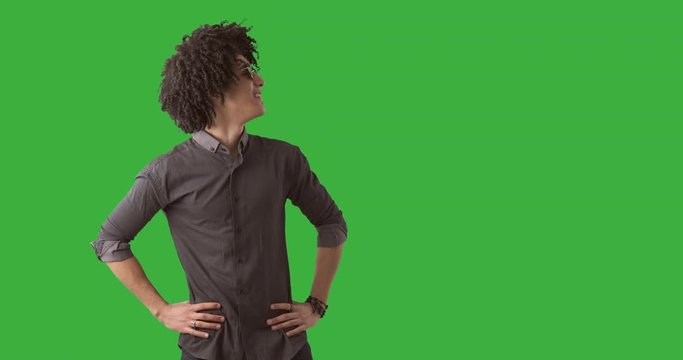 Handsome man looking sideways over green chroma key background