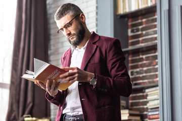 Businessman feeling interested reading book about astrology and money