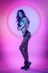 Cinematic night portrait of woman in  neon. High Fashion model girl in colorful bright neon lights posing in studio, portrait of beautiful woman in   jacket, underwear and trousers.