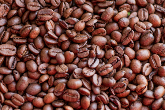 Texture of coffee beans scattered randomly. Brown texture. © Nastya