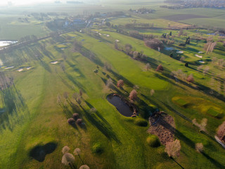 Aerial view of a golf course. Beautiful colorful trees and green course during autumn/winter season in the South of Belgium, Walloon Brabant.