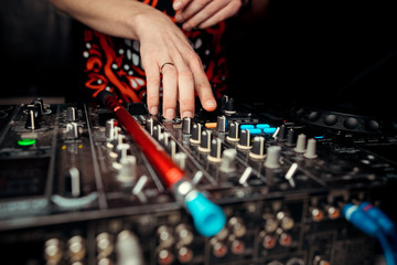 DJ console cd mp4 deejay mixing desk Ibiza house music party in nightclub with colored disco lights.