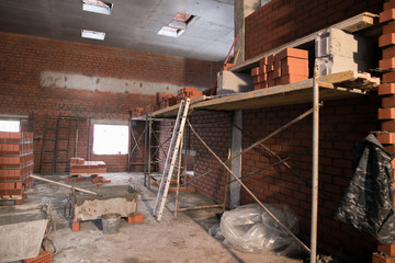 Construction site, tools, wheel barrow, sand and bricks at new house building