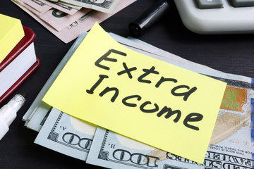 Extra Income written on a piece of paper and cash.