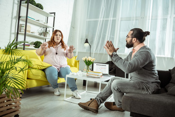 Attentive red-haired woman looking at her psychologist