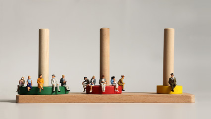 Miniature people sitting on wooden blocks.