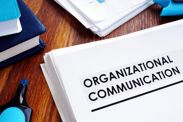 Documents about organizational communication on the desk.
