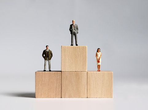 Wooden blocks and miniature people. The concept of gender discrimination in the organization.