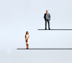 A miniature man and a miniature woman standing at different heights.