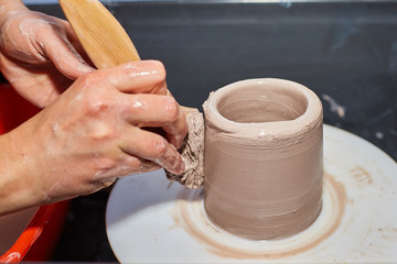 Fototapeta na wymiar Modeling of clay on a potter's wheel In the pottery workshop