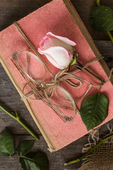 Pink rose on an old book in a vintage style.