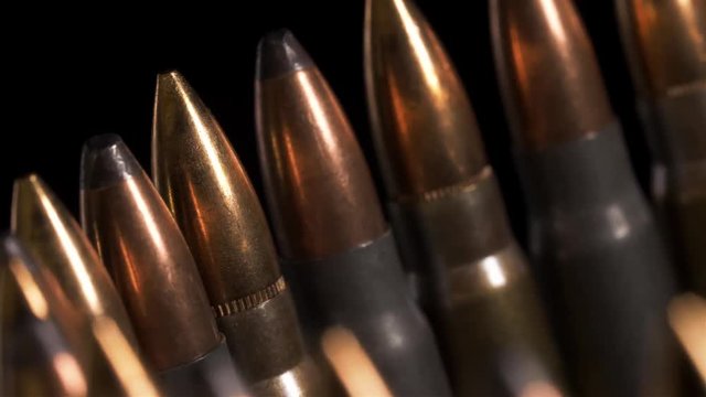 Detailed macro shot of rifle ammunition sorted in a circular row moving to the right.  The rear row of ammo is the focus point.