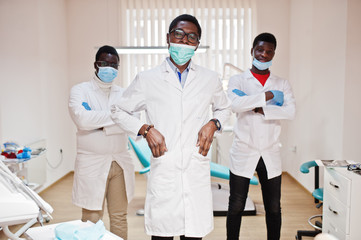 Three african american male doctor with crossed arms in dental clinic.