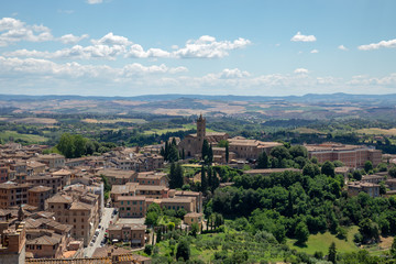 Panoramic view of Siena city with historic buildings and far away green fields