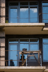 Balconies with trestle table of unfinished modern brick building under construction