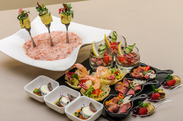 Buffet table with appetizers in a restaurant with krudite, guacamel, ceviche, bluefin, caviar, prawns and goat cheese