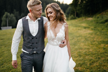 Fototapeta premium Beautiful wedding couple, bride and groom, in love on the background of mountains