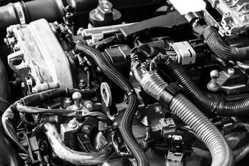 Fototapeta na wymiar Car gasoline engine. Car engine part. Close-up image of an internal combustion engine. Engine detailing in a new car. Black and white
