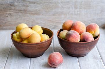 Ripe peaches and apricots in a clay dish.