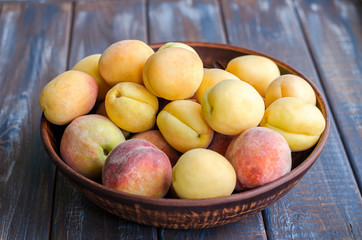 Ripe peaches and apricotsin a clay dish.