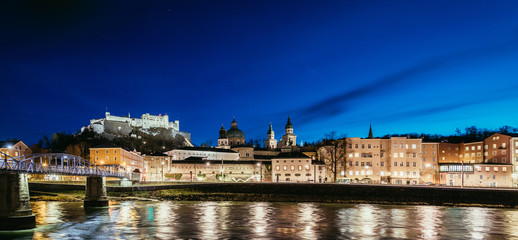 Fototapeta premium Night view in Salzburg: Historic old city and fortress Hohensalzburg, twilight hour