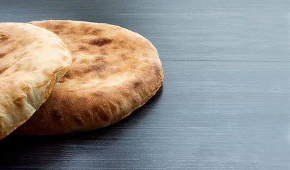 Two pita bread on wooden table. Copy space