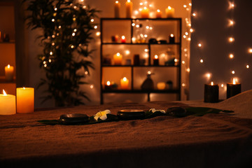 Massage stones with candles on table in spa salon