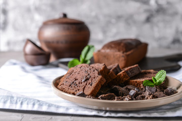 Plate with pieces of tasty chocolate cake on table