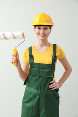 Beautiful female painter on light background