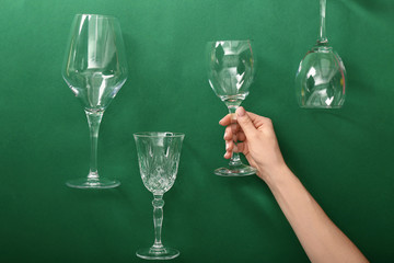Female hand with wine glasses on color background