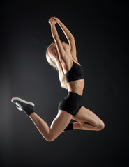 Young female dancer on dark background