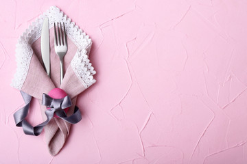 Cutlery for Easter table setting on color background