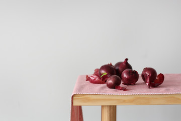 Red onion bulbs on table against light background