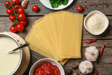 Lasagna sheets with ingredients on wooden table