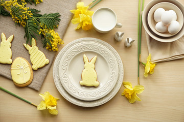 Tasty Easter cookies with milk on table