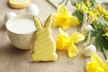 Tasty Easter cookie with milk on table