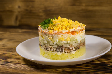Traditional russian salad Mimosa on wooden table