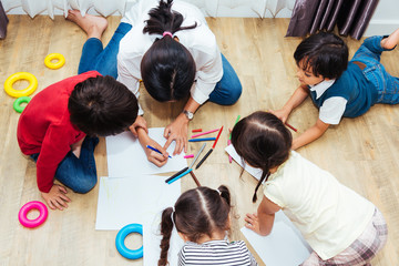 Family happy children group kid boy and girl kindergarten paint drawing on peper teacher education