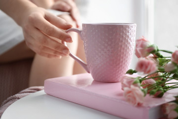 Woman drinking hot tea at home, closeup