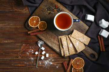 Cup of hot tea with sweets on wooden table