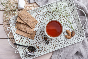 Cup of hot tea with cookies on tray