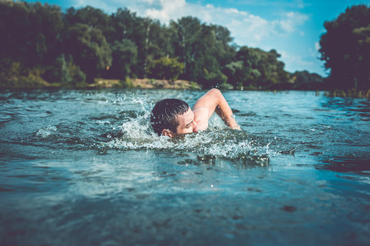 The young man swimming in the river