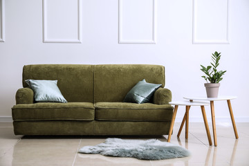 Comfortable sofa with table in interior of room