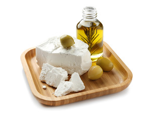 Plate with tasty feta cheese and olive oil on white background