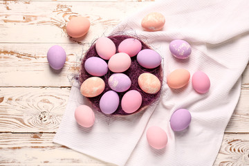 Plate with Easter eggs on wooden table